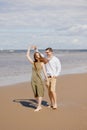 a couple of a man and a woman are walking on the beach or running along the sand along the seashore. beautiful and young Royalty Free Stock Photo