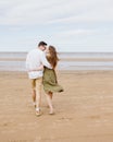 a couple of a man and a woman are walking on the beach or running along the sand along the seashore. beautiful and young Royalty Free Stock Photo