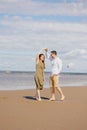 a couple of a man and a woman are walking on the beach or running along the sand along the seashore. beautiful and young Royalty Free Stock Photo