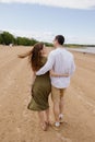 a couple of a man and a woman are walking on the beach or running along the sand along the seashore. beautiful and young Royalty Free Stock Photo
