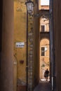 A couple man and woman walks through the narrow alleys of Terracina, Latina Italy. Via San Valentino plaque in the foreground