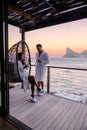 couple man and women drinking coffee on the balcony during sunrise in Cape Town South Africa. Royalty Free Stock Photo
