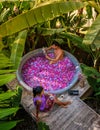 a couple of man and women in an outdoor bathtub in a green garden with leaves