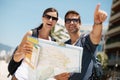 Couple, map and search with pointing on vacation, street and excited for giving direction. Woman, man and chart for Royalty Free Stock Photo