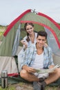 Couple with map sitting outside their tent Royalty Free Stock Photo