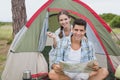 Couple with map sitting outside their tent Royalty Free Stock Photo