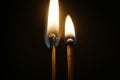 Couple of matches burning together with heat flame isolated on a black background Royalty Free Stock Photo