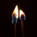 Couple of matches burning together with heat flame isolated on a black background Royalty Free Stock Photo