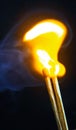 Couple of matches burning together with heat flame isolated on a black background. Royalty Free Stock Photo