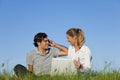 Couple on meadow with laptop and mobile phone Royalty Free Stock Photo