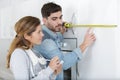 couple measuring furniture in store