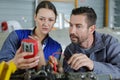 couple mechanics repairing engine race car