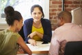 Couple Meeting With Financial Advisor In Office