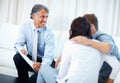 Couple meeting financial planner at home. Mature financial advisor showing financial plan to couple at home.