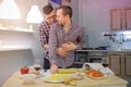 Couple of men gay flirts each other cooking a pizza together and drinking a wine. Royalty Free Stock Photo