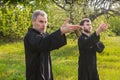 Couple men practice gymnastics in a green park Royalty Free Stock Photo