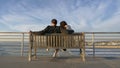 Couple men and woman at Hermosa Beach Pier famous La La Land scenary, enjoing beautiful view of ocean with sun flare low