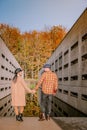 Couple men and woman hiking in the forest during autumn and small streaming water river with fall colors and orange and Royalty Free Stock Photo