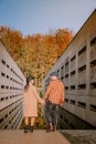 Couple men and woman hiking in the forest during autumn and small streaming water river with fall colors and orange and Royalty Free Stock Photo