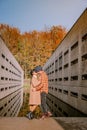 Couple men and woman hiking in the forest during autumn and small streaming water river with fall colors and orange and Royalty Free Stock Photo