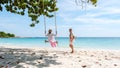 A couple of men and woman at a swing on the beach of Koh Samet Island Rayong Thailand Royalty Free Stock Photo