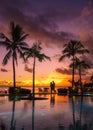 couple men and woman watching sunset on a tropical beach in Mauritius with palm trees by the swimming pool, Tropical Royalty Free Stock Photo