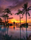 couple men and woman watching sunset on a tropical beach in Mauritius with palm trees by the swimming pool, Tropical Royalty Free Stock Photo