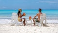 couple men and women on the beach with coconut drink, Praslin Seychelles tropical island Royalty Free Stock Photo