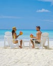 couple men and women on the beach with coconut drink, Praslin Seychelles tropical island Royalty Free Stock Photo