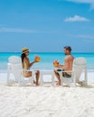 couple men and women on the beach with coconut drink, Praslin Seychelles tropical island Royalty Free Stock Photo