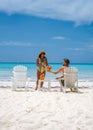 couple men and women on the beach with coconut drink, Praslin Seychelles tropical island with withe beaches and palm Royalty Free Stock Photo