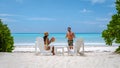 couple men and women on the beach with coconut drink, Praslin Seychelles tropical island with withe beaches and palm Royalty Free Stock Photo