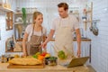 Couple man and woman chef cook by look the recipe from laptop