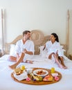 couple man and woman mid age having breakfast in bed bedroom of an appartment luxury hotel condo in Mauritius Royalty Free Stock Photo