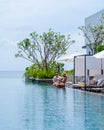 couple men and women relaxing on a beach chair in fron of the swimming pool at a luxury vacation Royalty Free Stock Photo