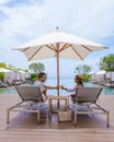 couple men and women relaxing on a beach chair in fron of the swimming pool at a luxury vacation Royalty Free Stock Photo