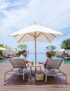 couple men and women relaxing on a beach chair in fron of the swimming pool at a luxury vacation Royalty Free Stock Photo