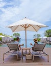 couple men and women relaxing on a beach chair in fron of the swimming pool at a luxury vacation Royalty Free Stock Photo