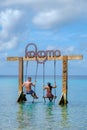 Couple at a swing in the ocean of Curacao Caribbean Island, Kokomo Beach Curacao Royalty Free Stock Photo