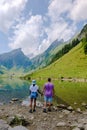 Couple of men and women visiting the Seealpsee lake in den Appenzeller mountains Ebenalp Switzerland