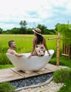 couple men and women on vacation at a homestay in Thailand in a bath tub with green rice paddy field Royalty Free Stock Photo
