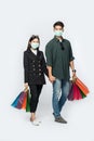 A couple of men and women wore masks and carried lots of paper bags to shop