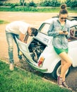 Couple in a moment of troubles during a vintage classic car trip