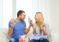 Couple with money and piggybank ot table at home Royalty Free Stock Photo