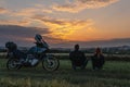 Couple of motobikers tourists sit on folding chairs and look to distance, ejoy the sunset view. Escape from the city. Outdoors Royalty Free Stock Photo