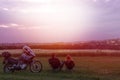 Couple of motobikers tourists sit on folding chairs and look to distance, ejoy the sunset view. Escape from the city. Outdoors Royalty Free Stock Photo