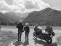 Couple of motorcyclists adventure riders. Green meadow in Zgornje Jezersko, to Kamnik-Savinja Alps on a sunny summer day in