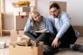 Couple moving in house, happy couple relaxing while sitting near cardboard boxes in new home, people, moving and real Royalty Free Stock Photo