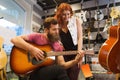 Couple of musicians with guitar at music store