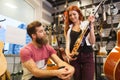 Couple of musicians with guitar at music store